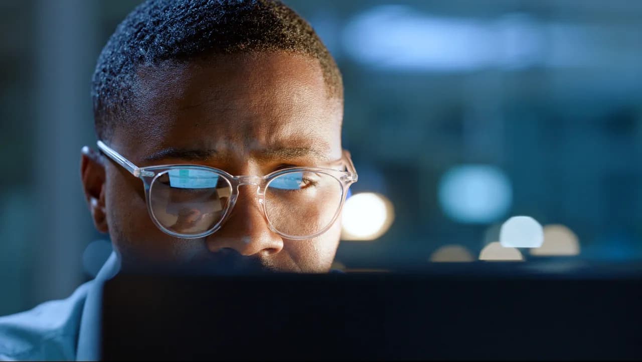 Loan officer focused on borrower data on a computer screen.