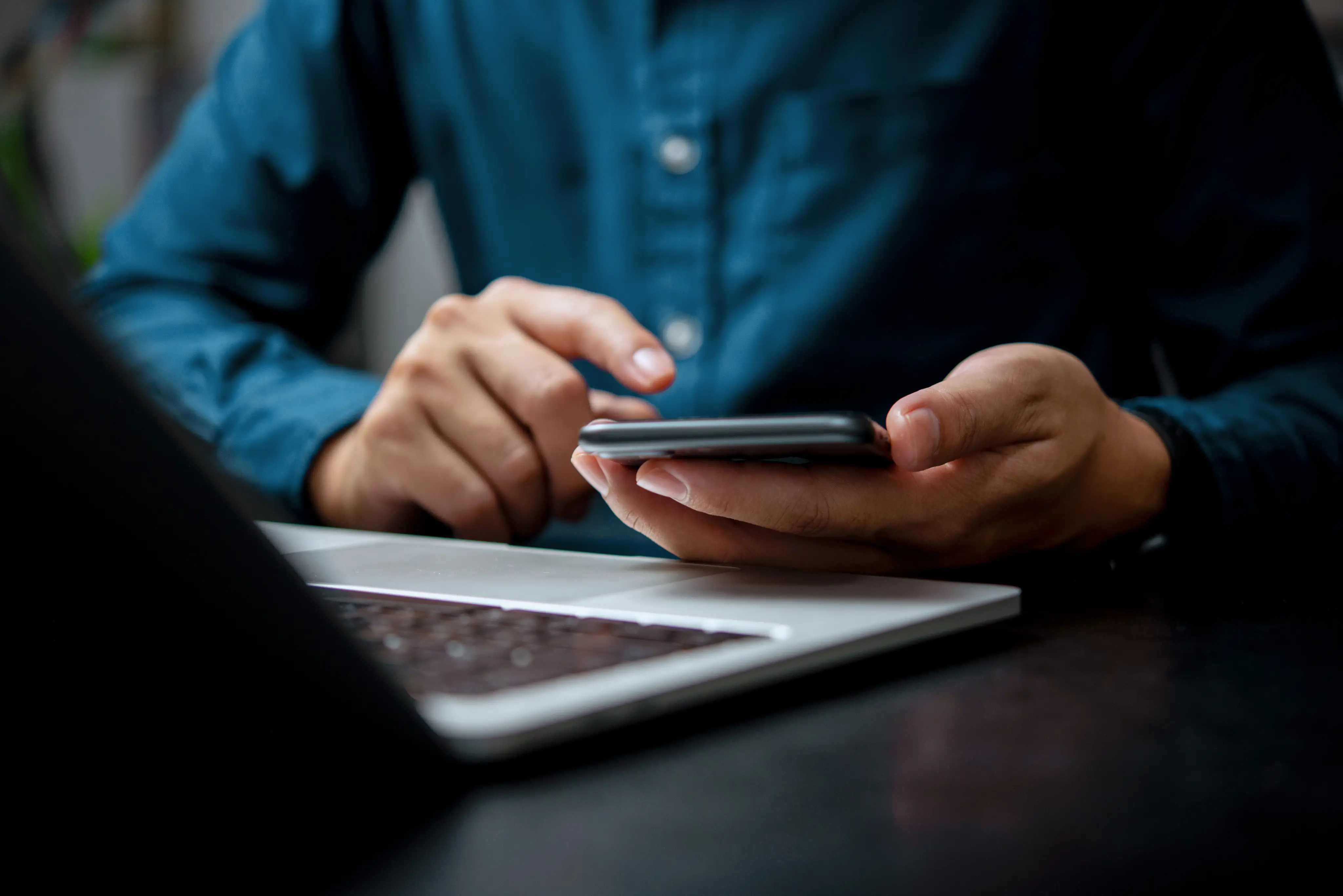 Mortgage professional checking a smartphone at their desk
