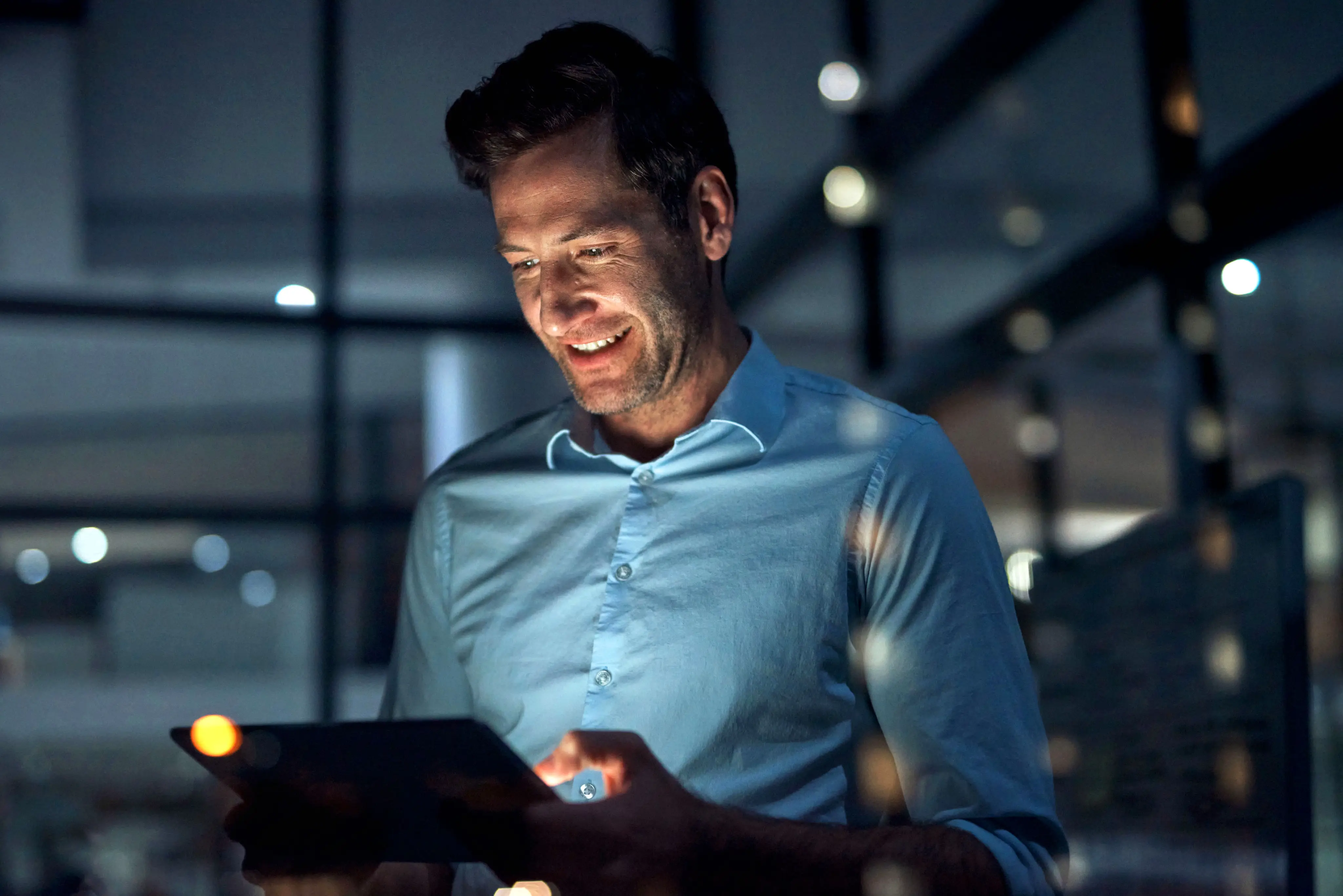 Professional reviewing reports on a tablet in a modern office
